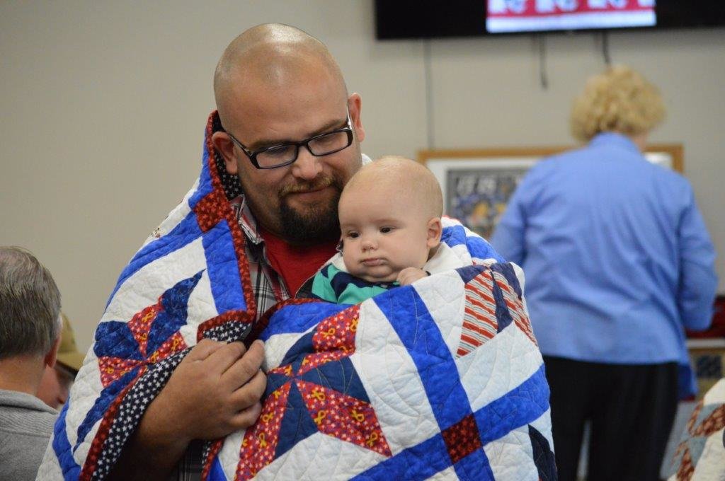 Army veteran Joey Knopfler of Winnsboro with his son, Jessup, after receiving his quilt at Saturday’s Quilts of Valor program at Stitchin’ Heaven in Quitman.